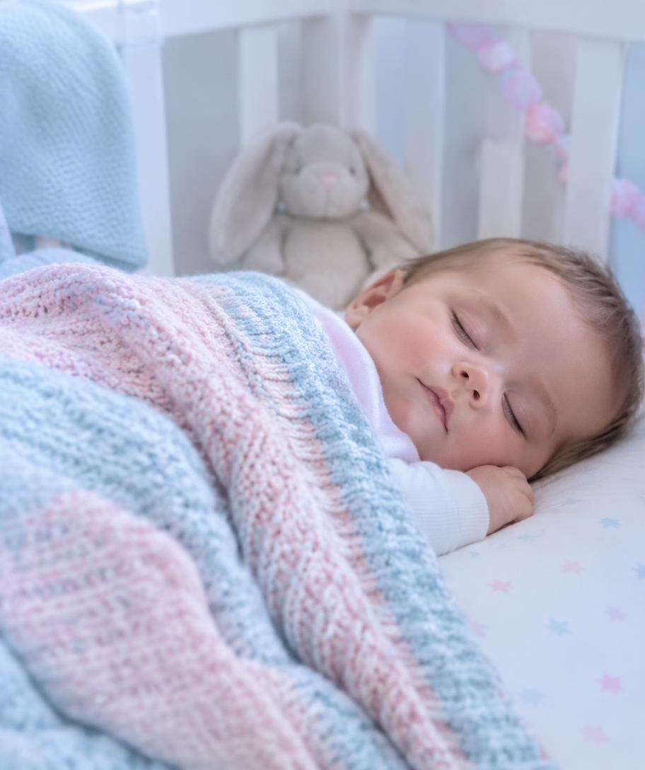 Örgü battaniyeye sarılmış uyuyan bebek